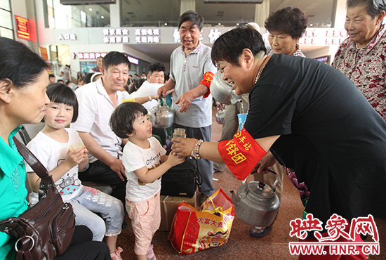 老年雷鋒團(tuán)”志愿者在候車廳為旅客送水。