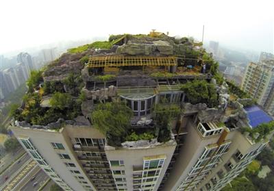 　　昨日，身穿橘黃色馬甲的工作人員在人濟(jì)山莊樓頂拆除違章建筑。新京報(bào)記者 吳江 攝