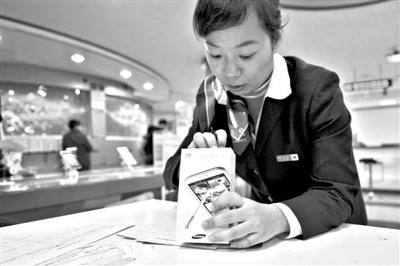 11月6日，北京移動西直門營業(yè)廳的工作人員在為顧客購買的4G手機登記。新華社發(fā)