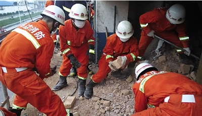 消防人員在清理熔鹽爐倒塌的廢墟。