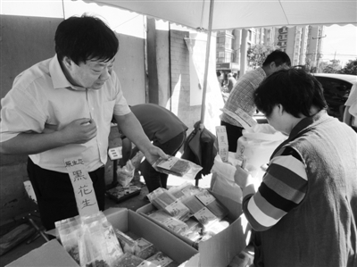 昨日，河南企業(yè)家劉春喜在京“練攤”，為顧客挑選綠豆。新京報(bào)記者 張玉學(xué) 攝