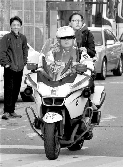 7日，首爾，警察將一名考生送抵考場。新華社發(fā)