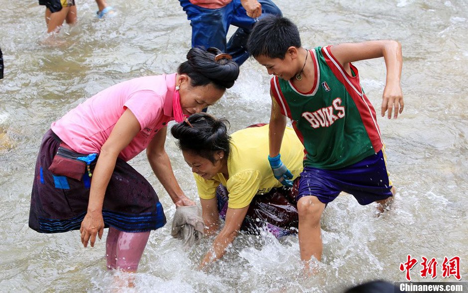 7月9日，村民在小河里摸魚搶魚。譚凱興 攝