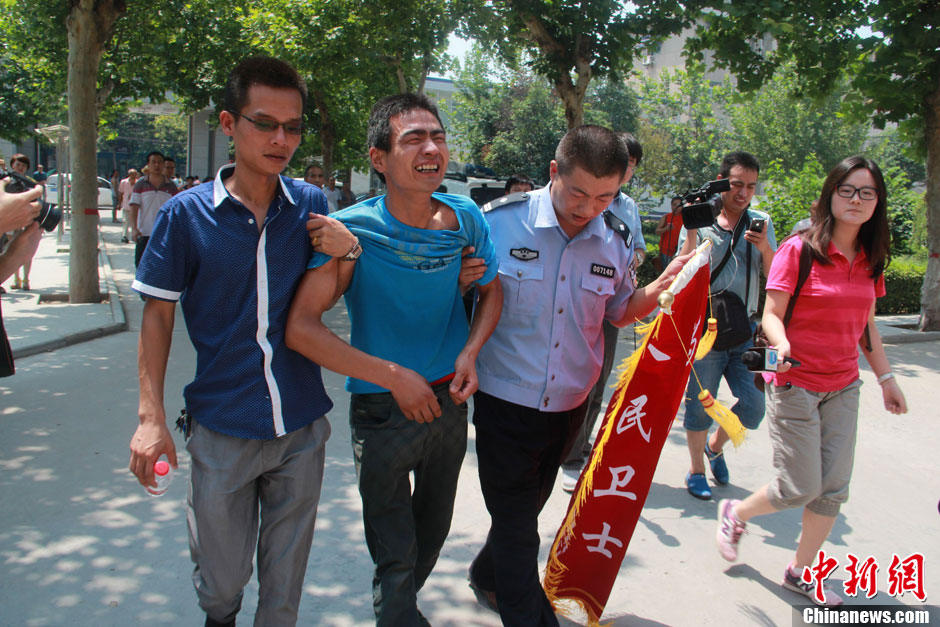 圖為獲救嬰兒父親情緒一度失控，當(dāng)?shù)鼐焦ぷ魅藛T對(duì)其進(jìn)行攙扶。張一辰 攝