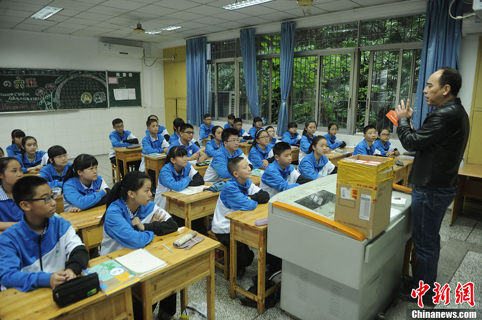 圖為老師正在向同學(xué)們講解用非智能手機對他們的好處。