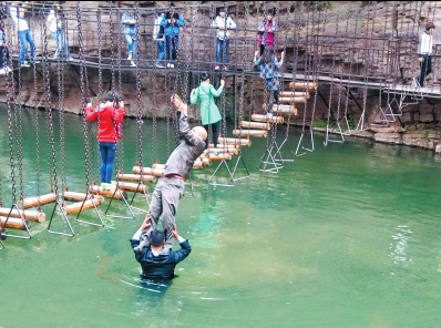 中年男游客正踩著景區(qū)安全員郭小明的肩膀過(guò)河。網(wǎng)友“@我的小名叫張孩”供圖