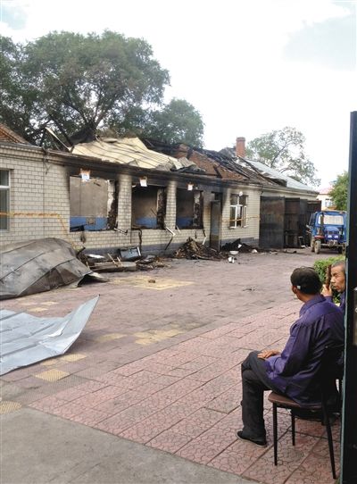 7月27日，海倫聯(lián)合敬老院內(nèi)，幾名老人看著對面被燒毀的特護(hù)病房。新京報(bào)記者 涂重航 攝