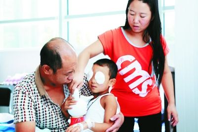 斌斌手術(shù)后第一天恢復(fù)良好，斌斌父母在用玩具逗他開心供圖/嚴益