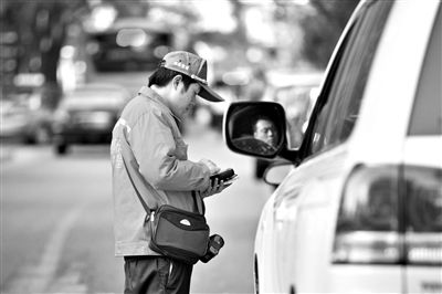 10月15日，朝陽區(qū)東大橋路，停車管理員從腰間掏出一個(gè)專用POS機(jī)，正在錄入停車信息。新京報(bào)記者 周崗峰 攝