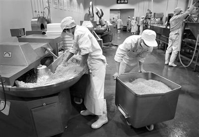 昨日，位于順義李遂開發(fā)區(qū)的慶豐包子鋪配送中心生產(chǎn)車間，工人們正在斬拌胡蘿卜餡料。