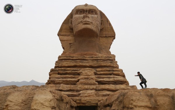 石家莊郊外，一名男子與山寨版獅身人面像合影留念。