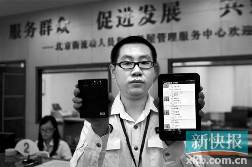 　越秀區(qū)北京街出租屋外來暫住人員管理服務(wù)中心的工作人員展示到出租屋登記來穗人員信息的儀器。