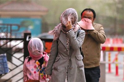 昨日下午，朝陽(yáng)區(qū)豆各莊，行人將紗巾裹在頭上防沙塵。