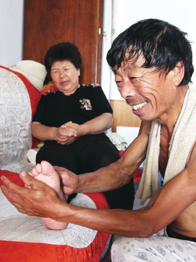 慈成富為老伴按摩。