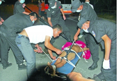 眾人合力將狂犬病發(fā)作的江某控制住。 孫東城 攝