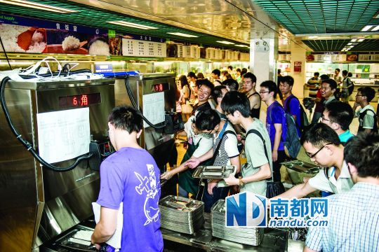昨日，華南理工大學(xué)一食堂內(nèi)，學(xué)生們正在使用新安裝的自動打飯機(jī)打飯。中新社發(fā)