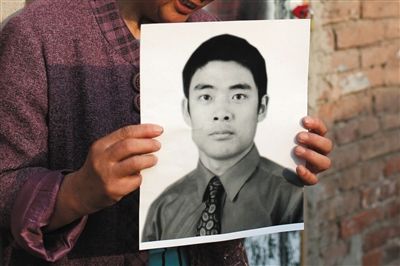 5月19日，朝陽北路，母親捧著張東文的遺像。新京報記者 侯少卿 攝