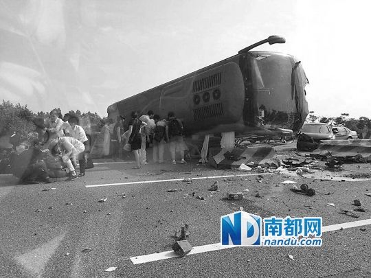 現(xiàn)場大客車側(cè)翻，玻璃碎落一地，車身卡在路邊水泥護欄上。 目擊者供圖