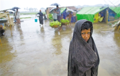 5月14日，緬甸若開邦實(shí)兌難民營(yíng)，羅興亞族難民在雨中行走。熱帶風(fēng)暴“馬哈森”即將登陸緬甸，這里的難民開始乘船撤離。