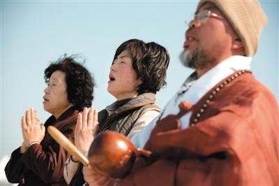 23日，一名僧侶引領(lǐng)人們?yōu)樗勒咂矶\。