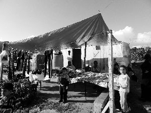 黎巴嫩一敘利亞難民營，難民支起攤鋪賣衣服掙錢。