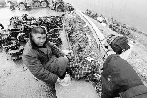 　出事司機(jī)的鞋找不到了，只好用塑料袋套著腳取暖