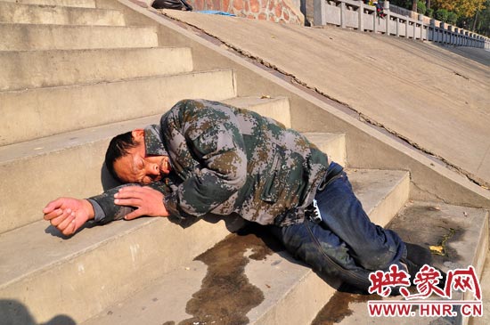 這名男子的衣服以及褲子全濕透了，水從衣褲里流出來，嘴里散發(fā)著濃烈的酒氣。