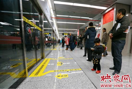 小朋友在等候區(qū)內(nèi)等待地鐵。