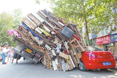 紅色小轎車被砸，卡在路邊動彈不得。