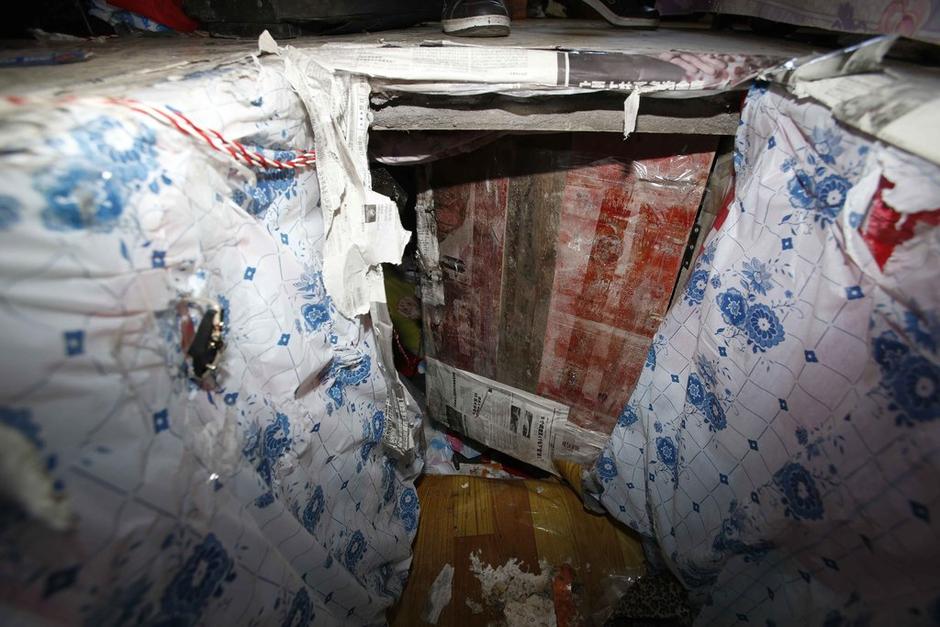 陳小龍?jiān)诔鲎馕萃猓孕杏謬鹨欢聡鷫?，安裝了一個(gè)門。圍墻上都是豎起的鐵釘，外面堆著土，鄰居猜是從地底挖出來的。洞口就在床邊，0.5米見方，深約1.5米。洞口表面一塊紙板掩蓋，打開紙板跳入洞底，是一扇小木門，木門外有插銷，可以從外面鎖上。