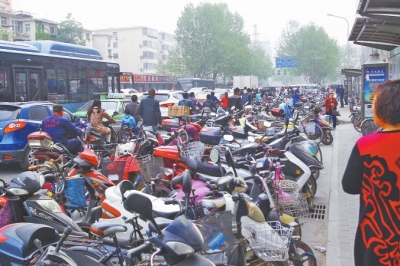 省人民醫(yī)院北門，路邊的公交站牌處停滿非機(jī)動(dòng)車，上、下客只能在快車道上。