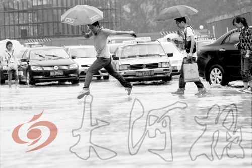 鄭州經(jīng)三路與北環(huán)交叉口處，積水較深，行人們不得不“練輕功”。 記者 白周峰 攝影