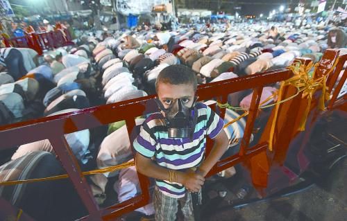 當?shù)貢r間28日晚，在埃及開羅納賽爾城，一名小男孩頭戴防毒面具參加穆兄會的集會示威。