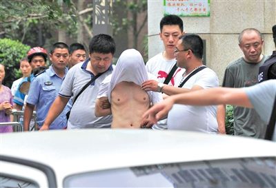 昨日，成都警方抓捕時與毒犯發(fā)生槍戰(zhàn)。一名男犯罪嫌疑人被警方押出。