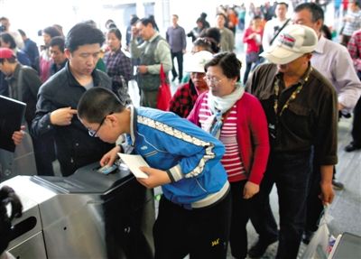 去年5月5日，14號線園博園站，乘客刷卡出地鐵。北京公交地鐵將實行計程票制，多乘坐多付費。