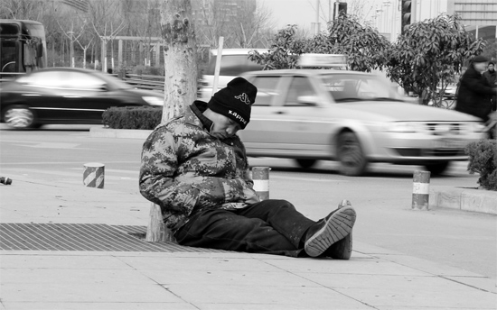 2月2日，鄭州市中州大道農(nóng)業(yè)路立交橋下，50歲的王文德打算在臨近春節(jié)前再接些零活兒，由于疲憊，他睡著