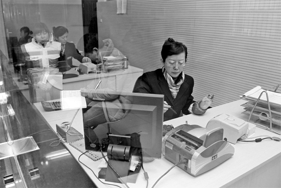 2月16日，鄭州市自來(lái)水總公司鄭東新區(qū)一營(yíng)業(yè)廳，柜臺(tái)內(nèi)工作人員正在為市民辦理業(yè)務(wù)