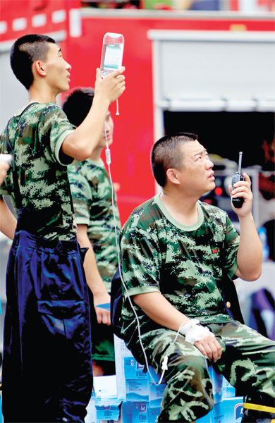 火場外，被消防戰(zhàn)士稱為“李大隊”的救援人員掛著吊瓶現(xiàn)場指揮