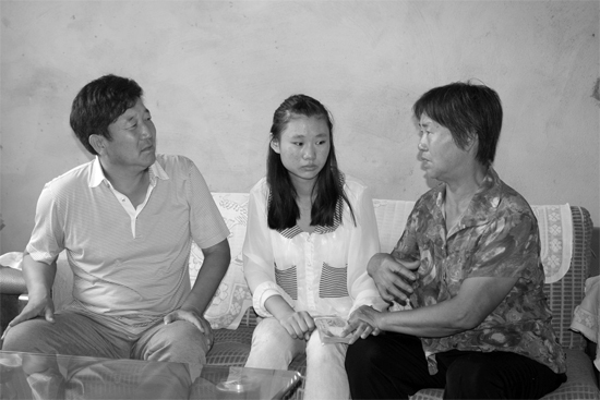 “商丘最美女兒”李丹（中）捐骨髓救母，愛心人士（左）送來1萬元愛心款