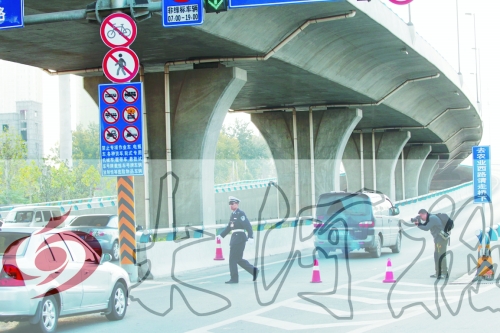 交警在東風(fēng)路從北向南上橋口處擺上反光錐，間歇放行
