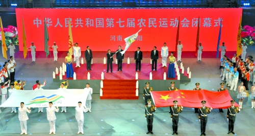 南陽市市長穆為民將農(nóng)運(yùn)會(huì)會(huì)旗遞交到下一屆東道主吉林省松原市市長李相國手里。