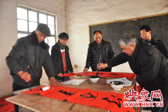 鞏義市魯莊鎮(zhèn)農(nóng)民書法愛好者正在寫春聯(lián)。