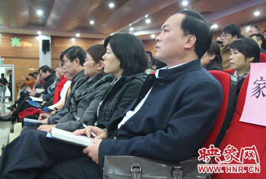 認(rèn)真聽取招生政策的學(xué)生家長。