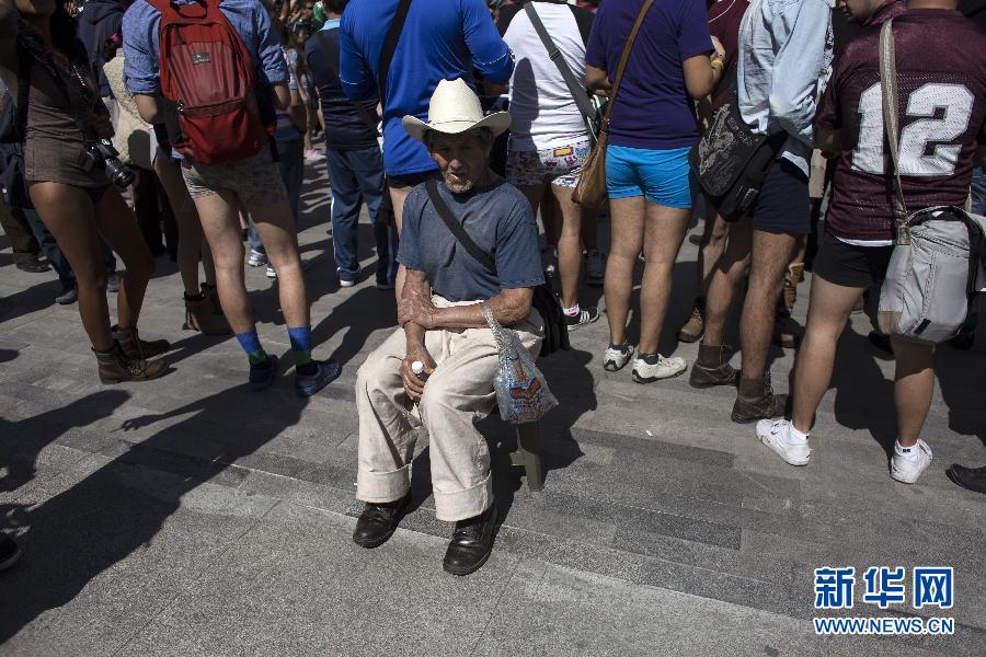 一名男子坐在參加不穿褲子搭地鐵的人群邊小憩。