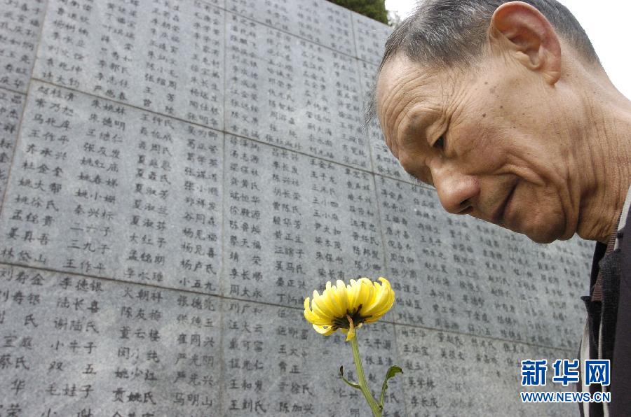 2006年4月5日，74歲的南京大屠殺幸存者佘子清手捧鮮花，祭奠被日軍殺害的母親。