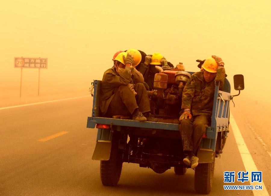 4月23日，一輛拉載公路施工人員的三輪車在沙塵暴中行駛在酒泉市瓜州縣城郊的公路上。