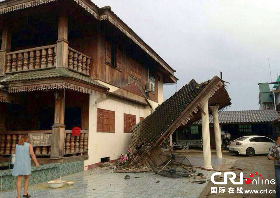 當?shù)貢r間2014年5月5日，泰國清萊，一名婦女看著受損的房屋。 圖片來源：東方IC