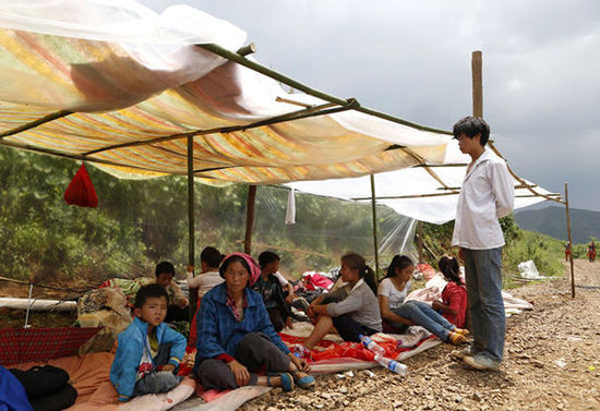 暴雨馬上來臨，村民們在簡易帳篷下躲雨。澎湃新聞 程藝輝 圖