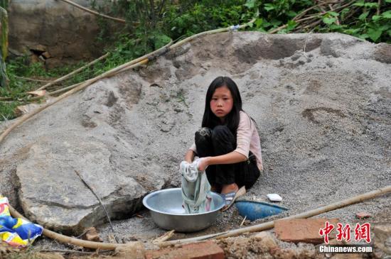 8月9日，云南巧家紅石巖村，10歲的劉鑫蕊在洗自己的衣服