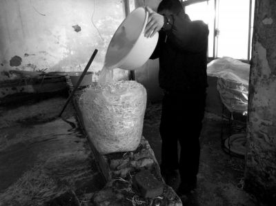 作坊內(nèi)工人用攪拌有漂白粉的藥水給豆芽增白。